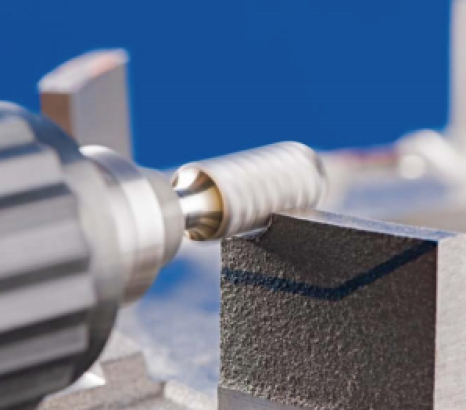 Worker using carbide burr on metal workpiece